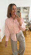 Lässige rosa Damenbluse im Oversize-Look mit Brusttasche und weiten Ärmeln – kombiniert mit grauer Hose
